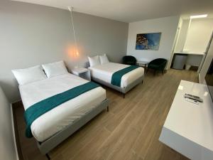 萨利纳斯Marina de Salinas的酒店客房设有两张床和一张桌子。