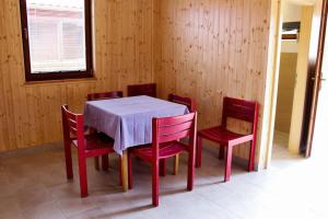 OrlíkChaty U Cvrků的一间带桌子和红色椅子的用餐室