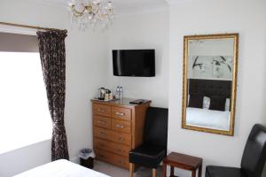 伯恩茅斯Southernhay Guest House的一间卧室配有梳妆台、镜子和椅子