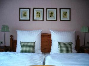 萨尔布吕肯贝利斯切沃尔夫萨尔布吕肯酒店的卧室配有两张床,墙上有三幅画