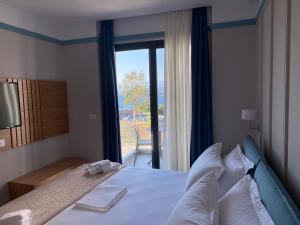卡萨米尔Hotel Olive Ksamil的一间卧室设有一张大床和大窗户