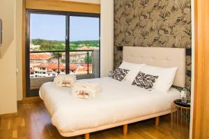 桑亨霍LaPerla Premium的卧室配有带枕头的床铺和窗户。