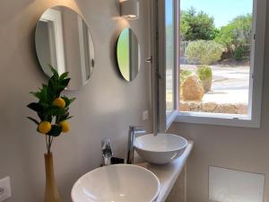 卡斯特尔萨多Luxury Home I LENTISCHI的一间带两个盥洗盆和两个镜子的浴室以及一个窗户。