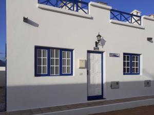 塞博河畔卡莱塔Casa El Salao的白色的建筑,有蓝色的窗户和门