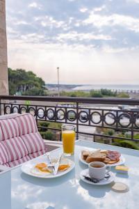 乌尔齐尼亚得里亚海公寓酒店的一张桌子,上面放着两盘食物和一杯橙汁