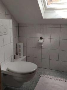巴特基辛根Haus Holzheimer的白色的浴室设有卫生间和窗户。