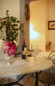 切法卢B&B del Giglio的一张桌子,上面放着一瓶葡萄酒和两杯酒杯