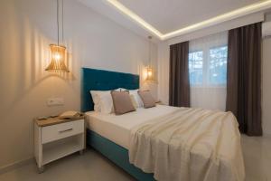 扎金索斯镇Margaritari Apartments的一间卧室配有一张带蓝色床头板的床和窗户