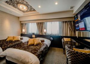 东京APA Hotel Ueno Hirokoji的酒店客房设有两张床和一台平面电视。