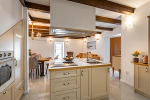 克尔克Villa Frana的厨房配有白色橱柜、水槽和桌子