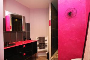 莱瓦尔坦Au Domaine de PY的粉红色的浴室设有水槽和镜子
