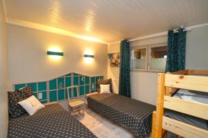 莱瓦尔坦Au Domaine de PY的小房间设有两张床和一张双层床。