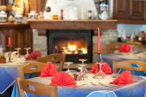 Villar PelliceHotel Palavas的一张桌子,上面有红色的餐巾纸和蜡烛,上面有一个壁炉