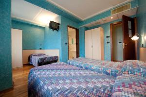 Villar PelliceHotel Palavas的酒店客房,设有两张床和蓝色的墙壁