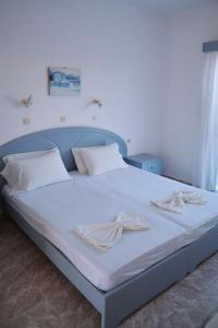 凯法洛斯Sevoula studios的一张带白色床单和白色枕头的床