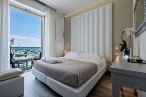 里米尼斯特拉多罗酒店的一间卧室设有一张大床和一个大窗户