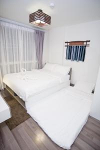 清迈HOC2 Apartment Santitham Chiang Mai的带窗户的客房内的2张白色床