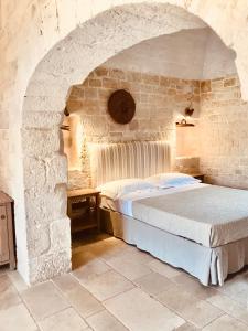 奥斯图尼Masseria Morrone的卧室配有一张石墙床
