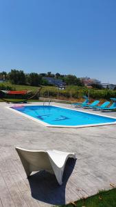 莱里亚Cargal leiria的游泳池前面设有长凳