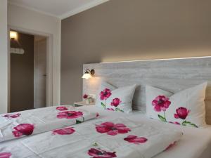 恩基尔希怀格史蒂夫斯霍夫宾馆的一张白色的大床,上面有粉红色的花朵