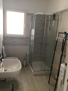 罗萨岛Isuledda的一间带玻璃淋浴和水槽的浴室