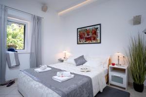 赫瓦尔LUXOR Hvar - Main Square Apartments的白色卧室,配有带毛巾的床