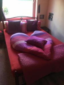 福纽德MG Apartmanház的床上铺有紫色枕头的床