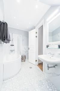 里加Forums Boutique Hotel的白色的浴室设有浴缸和水槽。