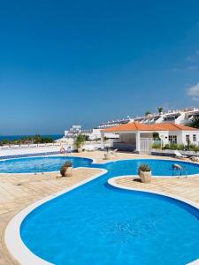 阿德耶BuenaVista Romantic Bungalow in Costa Adeje的度假村内的一个蓝色海水游泳池
