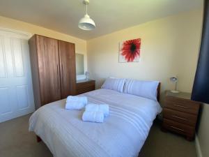 廷塔杰尔Copthorne - Tintagel的卧室配有白色的床和2条毛巾