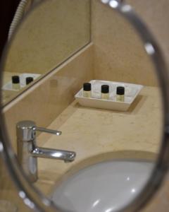 丰沙尔大教堂酒店的浴室盥洗盆的镜子反射和洗浴用品