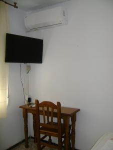 诺韦尔达航道公寓旅馆的一张桌子、椅子和墙上的电视