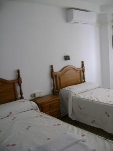 诺韦尔达航道公寓旅馆的一间卧室配有两张床、床头柜和两张床。