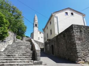 斯丹尼Apartmaji in sobe Odlična hiša Štanjel的一座古老的石头楼梯,有教堂和塔楼