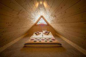 考斯赛力克Kirowy Domek的一张位于带窗户的小型木制客房内的床铺