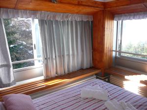 马里尔伊瓦Appartamento Sole Alto的一间卧室设有一张床和两个窗户。