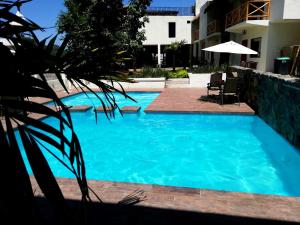 希利特拉Hotel Sierra Linda的大楼前的蓝色海水游泳池