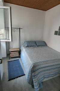 塞辛布拉Vila Azul的一间卧室配有一张床和蓝色地毯