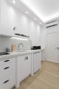 纳克索乔拉Hora Seaside Suites的厨房配有白色橱柜、水槽和门