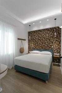 纳克索乔拉Hora Seaside Suites的一间卧室设有一张床和砖墙