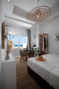纳克索乔拉Hora Seaside Suites的一间带大床的卧室和一间餐厅
