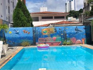 若昂佩索阿卡博布兰科酒店的墙上挂着壁画的游泳池