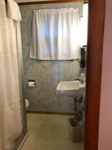 旧奥查德比奇马科特汽车旅馆的一间带水槽和卫生间的浴室以及窗户。