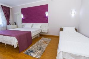 维纳斯Vila Cataleya的客房设有两张床和紫色窗户。