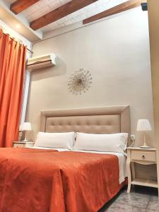 巴塞罗那奥尔良旅馆的一间卧室配有一张带橙色毯子的大床