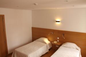 英雄港则奈特酒店的酒店客房,设有两张床,墙上有灯