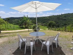 坎皮纳斯Casa de Campo-Linda Vista-SOUSAS的一张桌子和椅子,配有白色遮阳伞