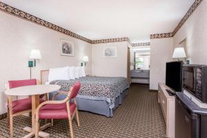 拜伦拜伦戴斯酒店的酒店客房带一张床、一张桌子和椅子
