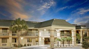 拜伦拜伦/南梅肯速8酒店 的一座棕榈树环绕的大建筑