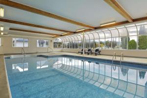 萨蒙阿姆萨蒙阿姆旅程住宿酒店的一座大型游泳池,位于一座带窗户的建筑内